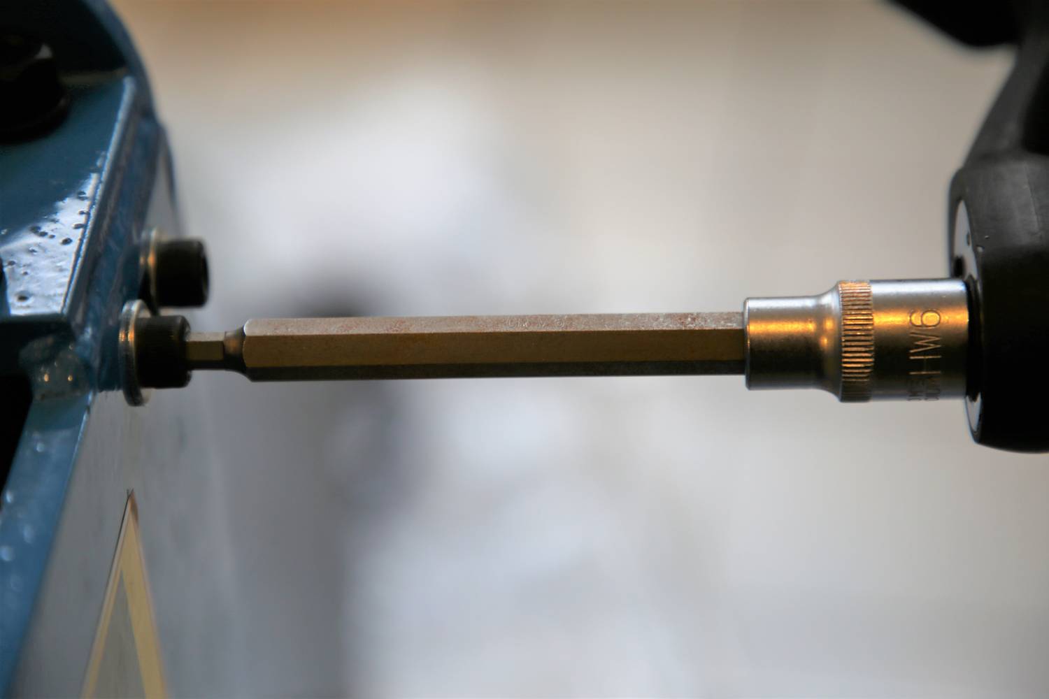 Ein Schraubendreher wird verwendet, um eine Schraube in ein Metallgerät zu drehen. Fokus auf den Schraubendreherkopf.