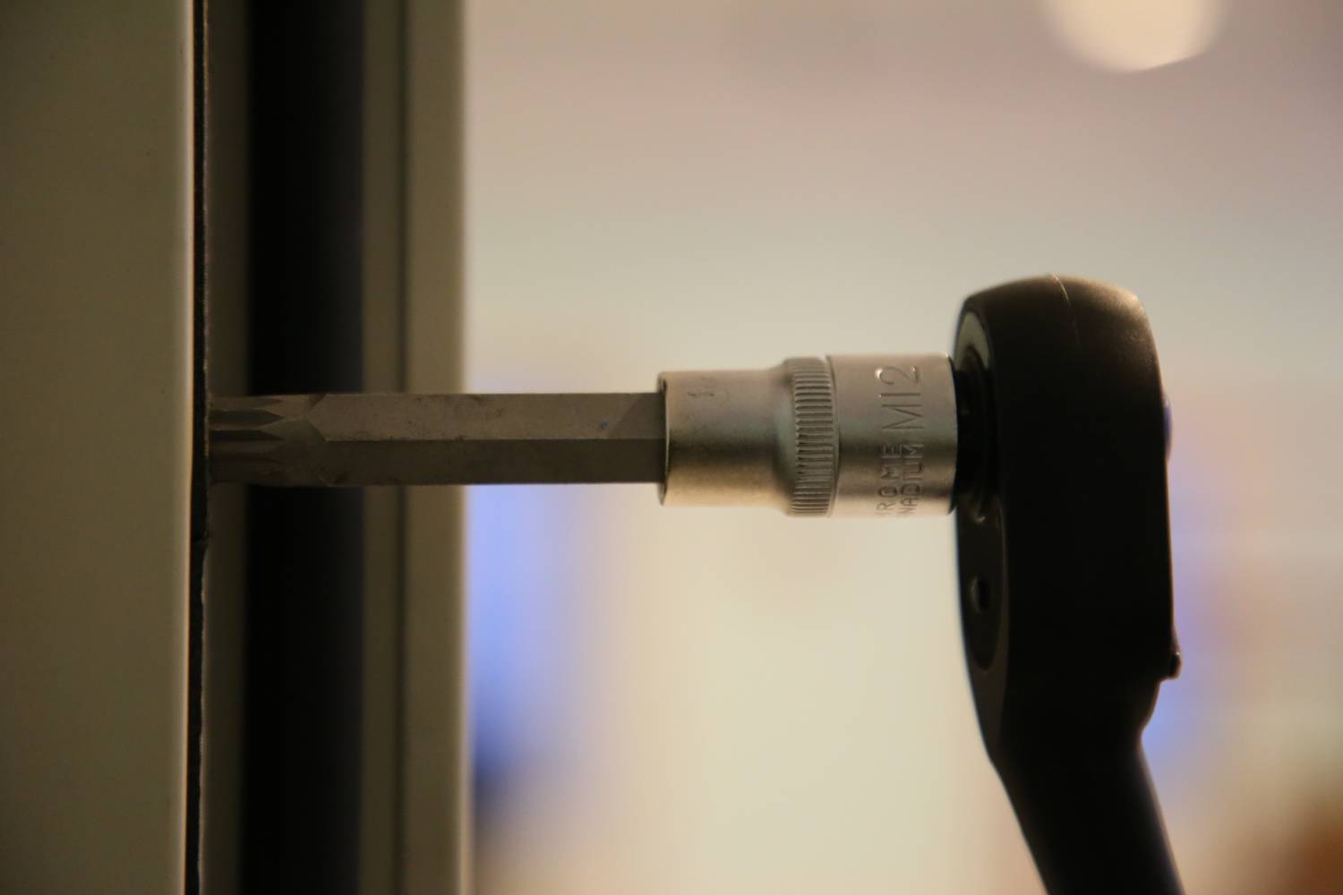 Ein Schraubenzieher steckt in einer Türverriegelung, möglicherweise wird die Tür repariert oder gewartet.