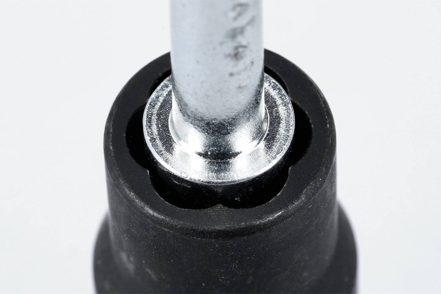 Eine Nahaufnahme eines schwarzen Schraubenschlüssels, der einen silbernen Bolzen hält.