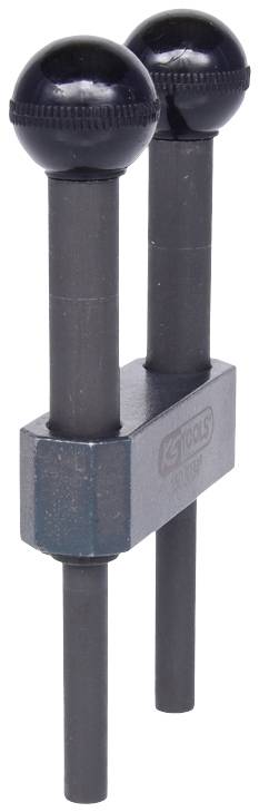 Zwei schwarze, kugelförmige Nockenwellen-Arretierungshilfen an Metallhalterung zur Motorreparatur sichtbar.