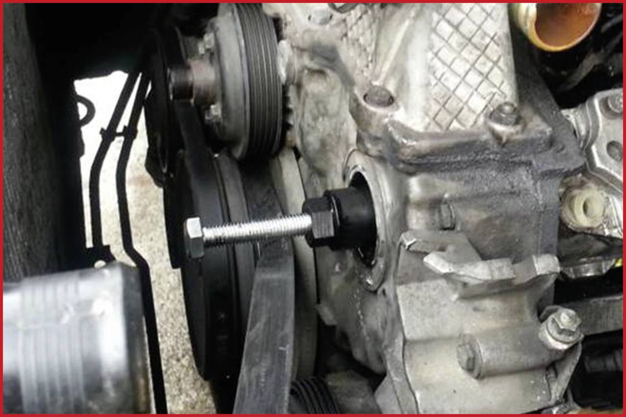 Nahaufnahme eines Autoteils, das einen Bolzen im Motorblock zeigt. Der Bolzen ist in eine Öffnung eingeschraubt, mechanische Details sichtbar.