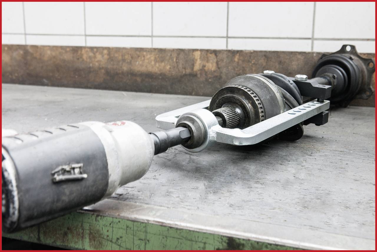 Eine Maschine wird auf einer Arbeitsfläche repariert. Ein Elektrowerkzeug verbindet sich mit einem Maschinenteil, um es zu justieren oder zu reparieren.