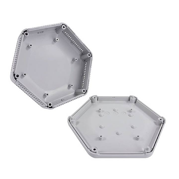 Zwei hexagonale, graue Plastikgehäuse mit Bohrungen und Rillen, möglicherweise für Elektronikbauteile. Im geöffneten Zustand gezeigt.