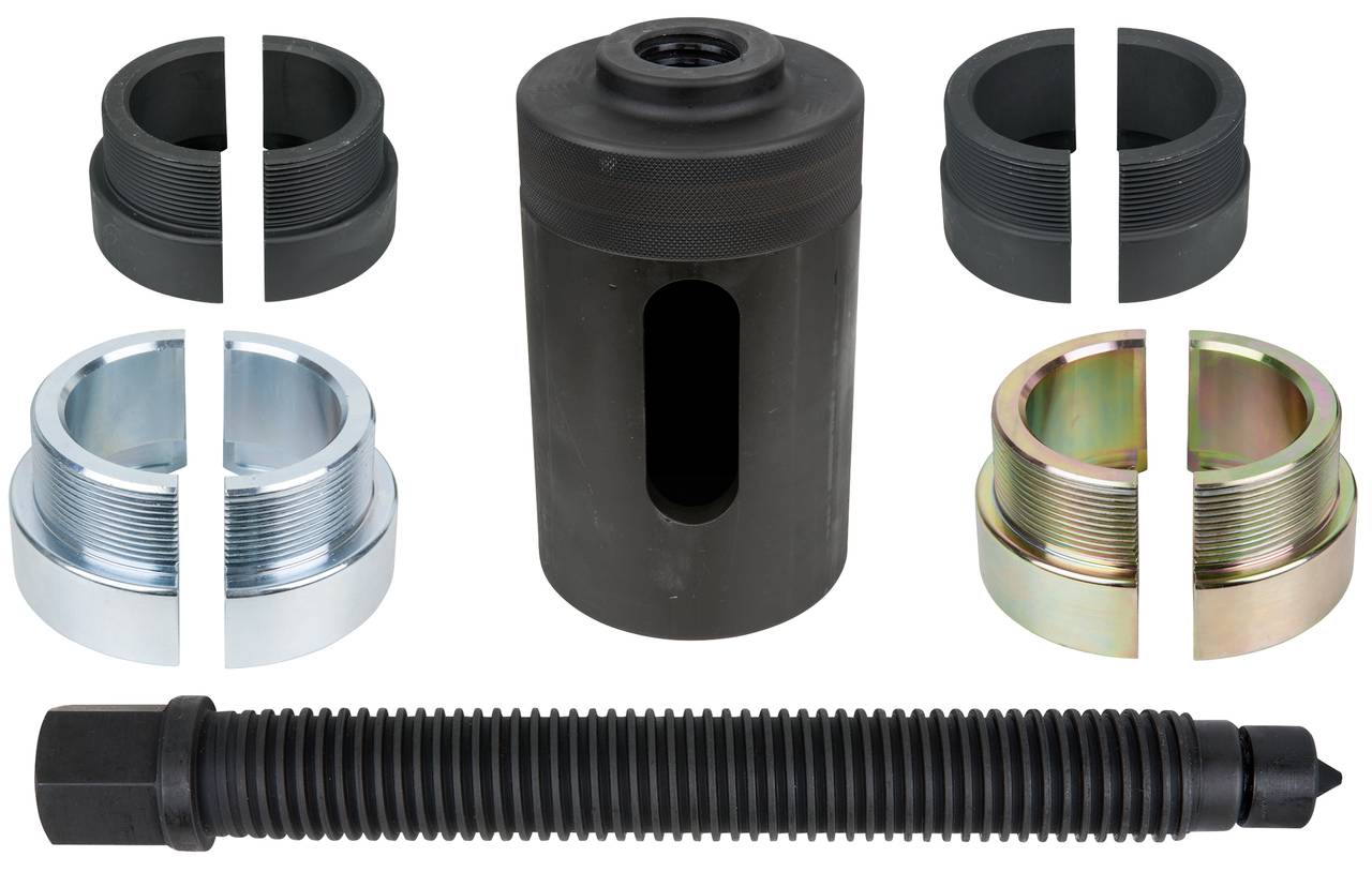 Teile eines Werkzeugsatzes zur Achsmontage: zentraler Zylinder, Schrauben, verschiedene Adapter in Metall- und Kunststoffoptik.