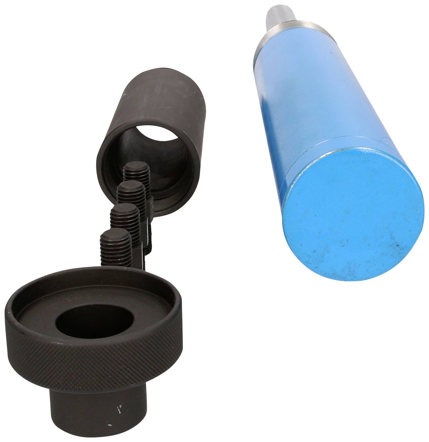 Ein Zylinder mit blauem Gehäuse liegt neben einer schwarzen, hohlen Hülle und einer Rändelschraube. Es könnte sich um Teile eines mechanischen Geräts handeln.