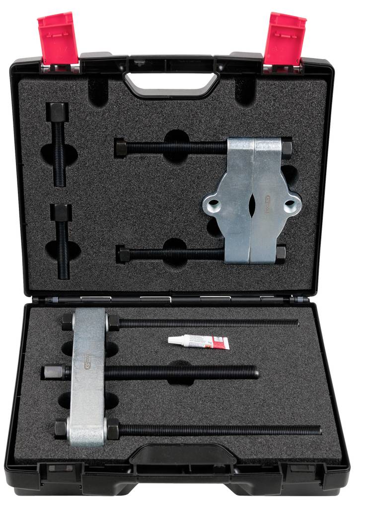 Geöffneter Werkzeugkoffer mit zwei Spannvorrichtungen, Schrauben und einer Tube Klebstoff. Enthält Halterungen und Montagematerial.