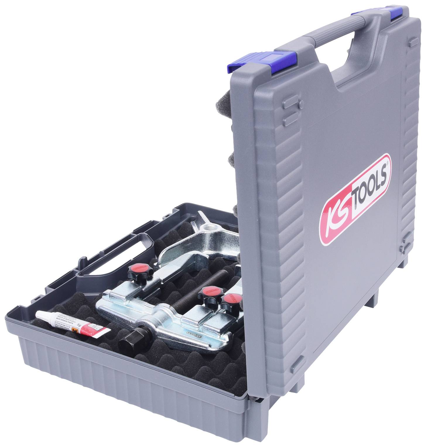 Grauer Werkzeugkoffer mit dem Logo von KS Tools, geöffnet, zeigt Werkzeuge und Zubehör in Schaumstoffeinsätzen, einschließlich eines Klebstoffröhrchens.