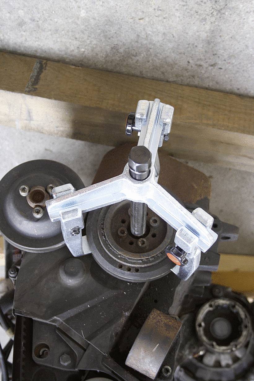 Ein Metallwerkzeug ist an einem mechanischen Bauteil befestigt und scheint bei der Bearbeitung oder Demontage zu helfen.