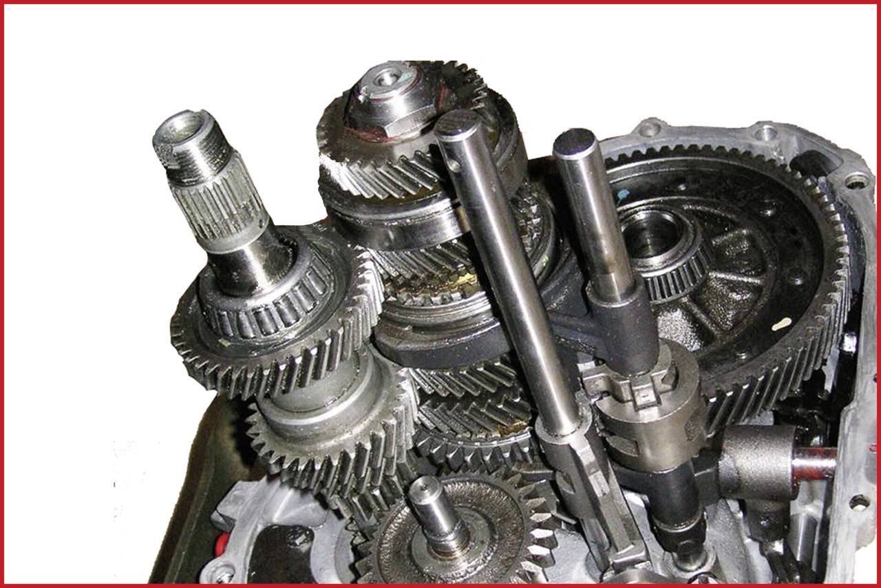 Ein offenes Getriebe mit mehreren Zahnrädern und Wellen. Die komplexe Anordnung von Zahnradsegmenten zeigt mechanische Details.