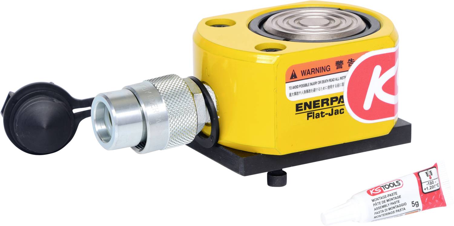 Ein hydraulischer Zylinder mit gelbem Gehäuse und rot-weißem Warnhinweis, daneben eine kleine Tube mit einem Schmiermittel.