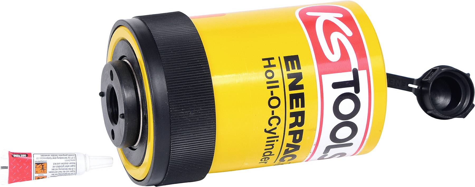 Ein gelber Hydraulikzylinder von Enerpac mit der Aufschrift 'Holl-O-Cylinder' liegt neben einer kleinen Tube Schmiermittel.