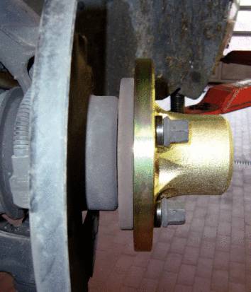 Nahaufnahme einer Radnabe mit Bremsscheibe und Radlager an einem Fahrzeug.rostige Schrauben und Metalloberflächen zeigen Gebrauchsspuren.