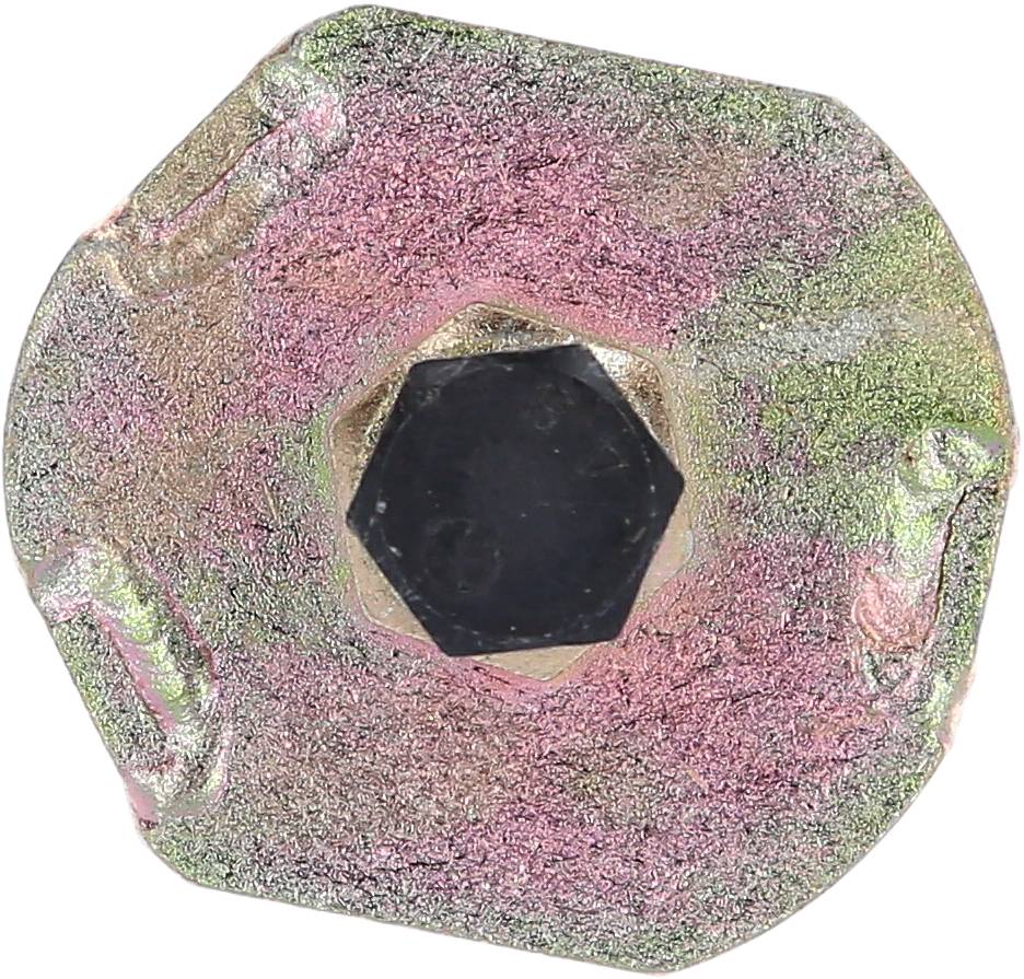 Ein sechseckiger Schraubenkopf aus Metall mit abgenutzten, bunten Oberflächenstrukturen.