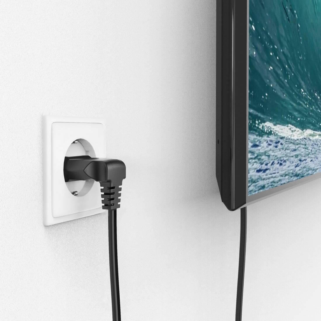 Ein Fernsehkabel ist in eine Steckdose eingesteckt, während ein Flachbildschirm an der Wand ein Meeresbild zeigt.
