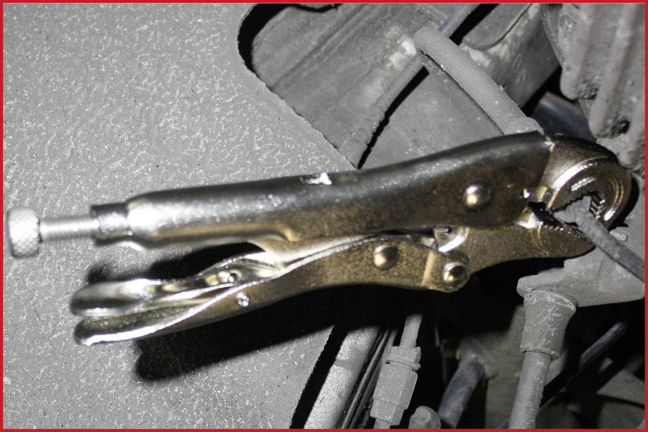 Feststellzange hält eine Metallstange, verwendet für Reparatur oder Befestigung.