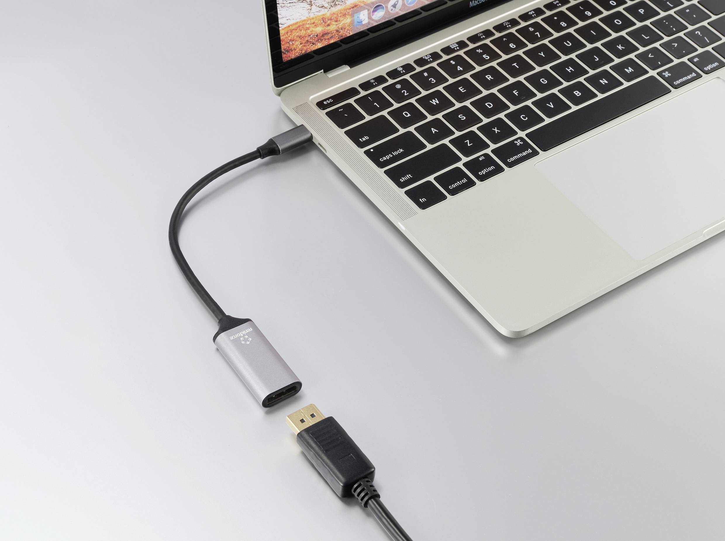 Ein Laptop mit geöffnetem Display ist mit einem HDMI-Kabel verbunden, das an einen USB-C-Adapter angeschlossen ist.