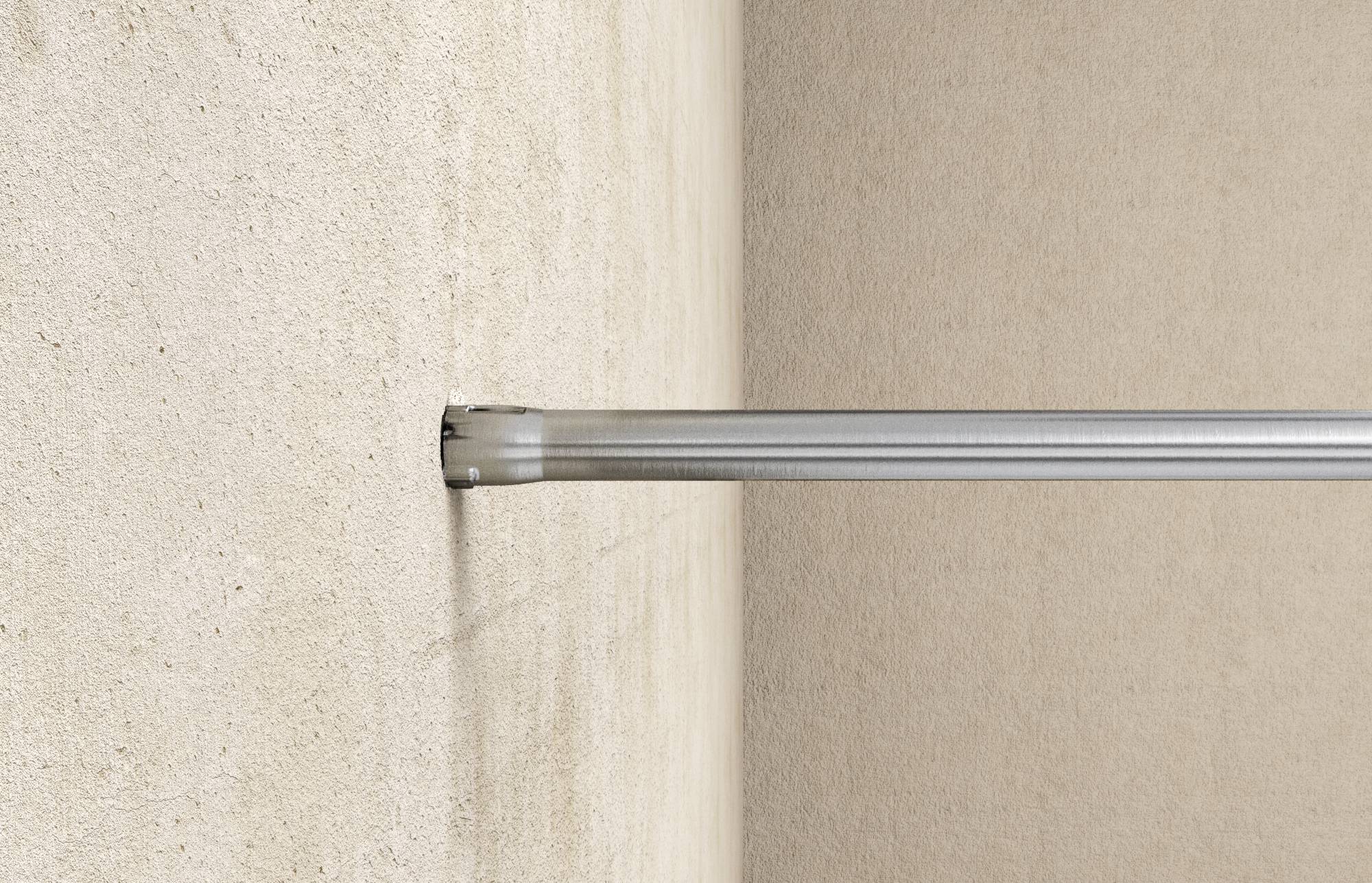Eine horizontale Metallstange ist in eine beige Wand montiert.