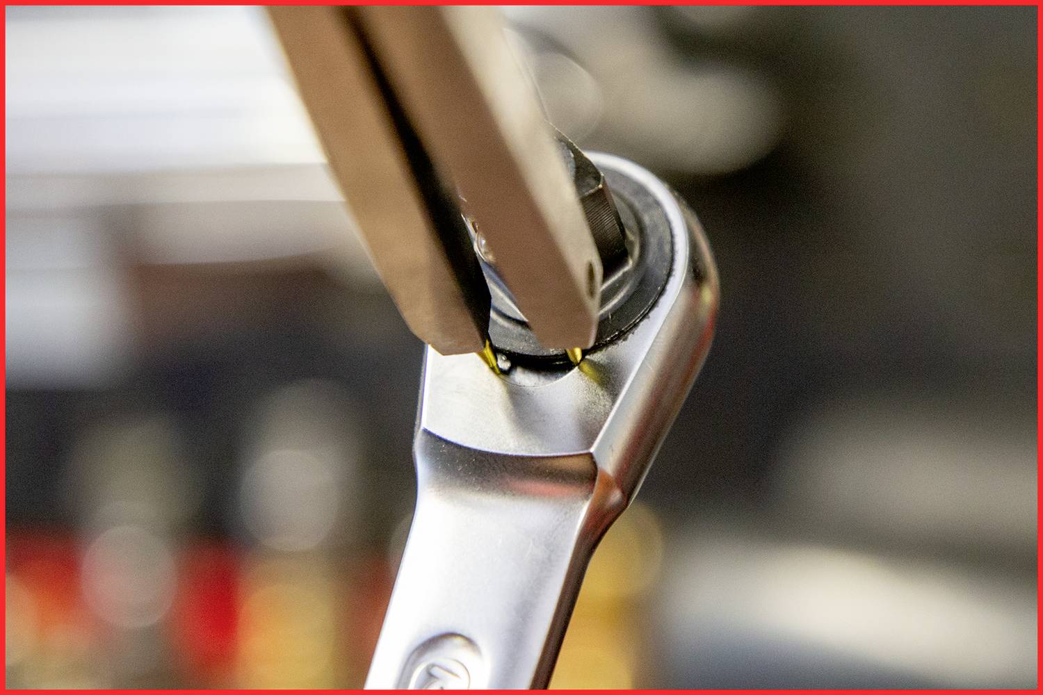 Nahaufnahme eines Schraubenschlüssels bei der Arbeit an einer Mutter. Die Szene zeigt präzise handwerkliche Arbeit mit Fokus auf das Werkzeug.