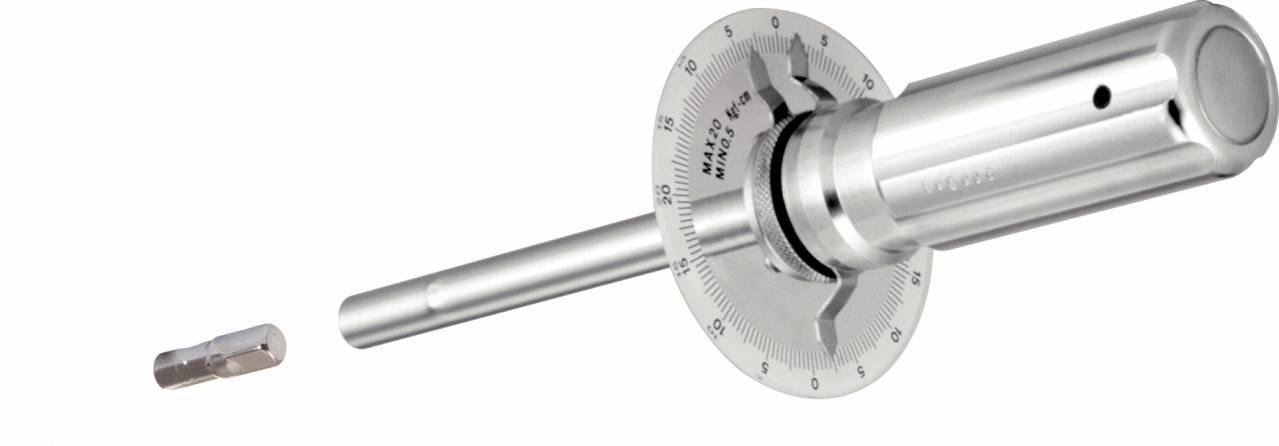 Ein zylindrisches Metallwerkzeug mit Skala, das in ein Schloss eingeführt wird, und ein kleiner, separater Metallzylinder.