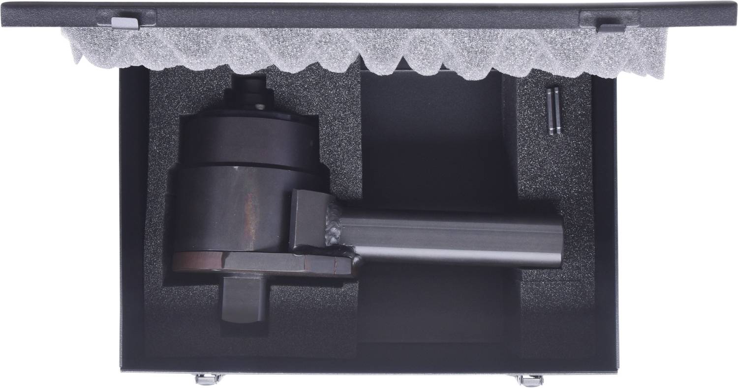 Maschinenteil in einer gepolsterten Box mit separatem Fach und kleinerem Metallteil.