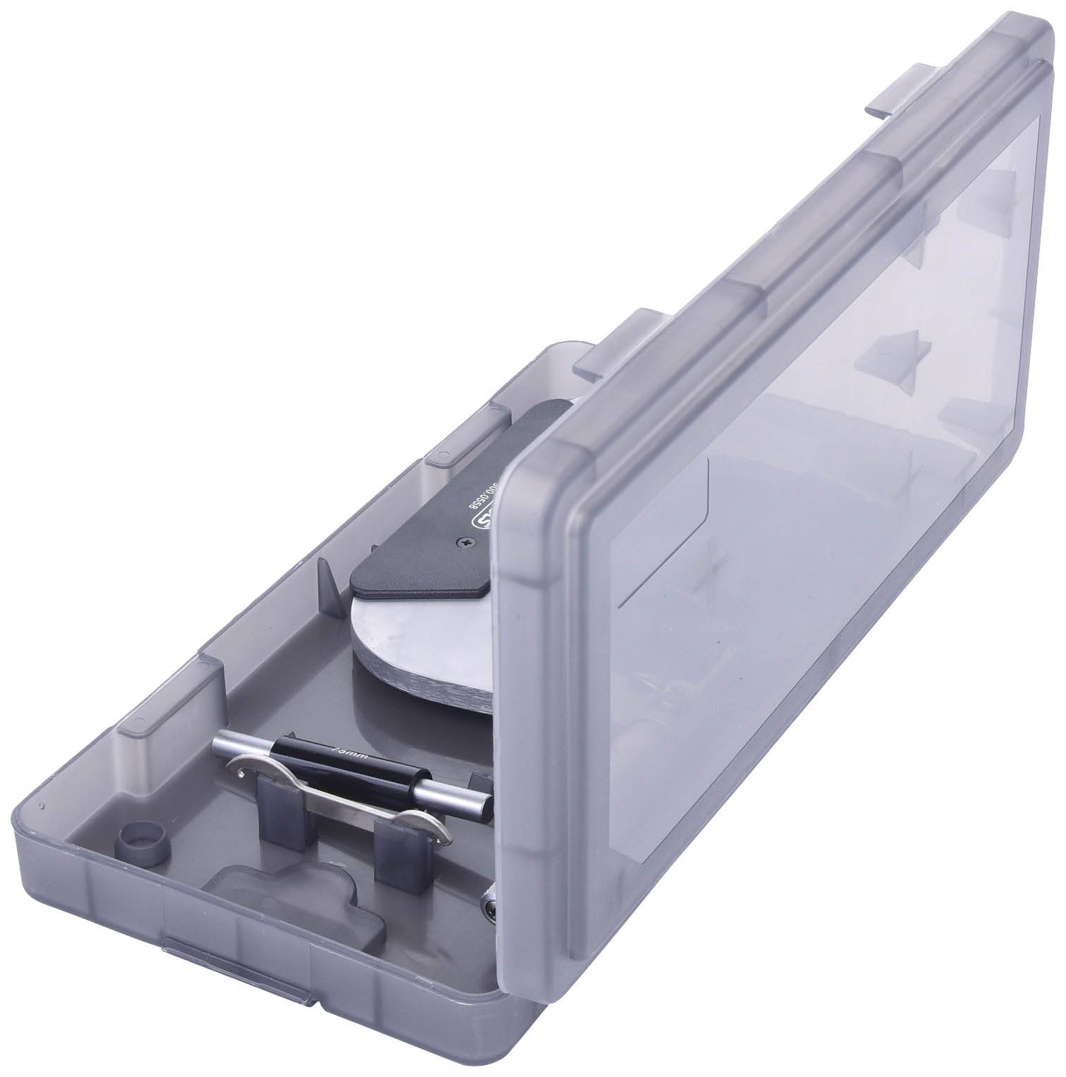 Ein geöffnetes Kunststoff-Etui mit einem mechanischen Gerät und Zubehör darin, vermutlich ein Werkzeug-kit, auf weißem Hintergrund.