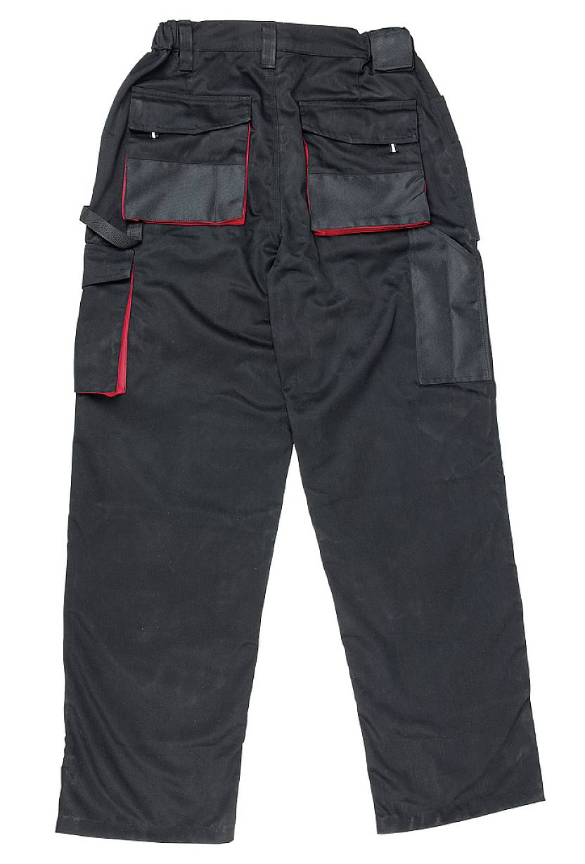 Schwarze Arbeits- oder Cargo-Hose mit mehreren Taschen, die für Werkzeugaufbewahrung geeignet sind. Rote Akzente an den Taschenrändern.