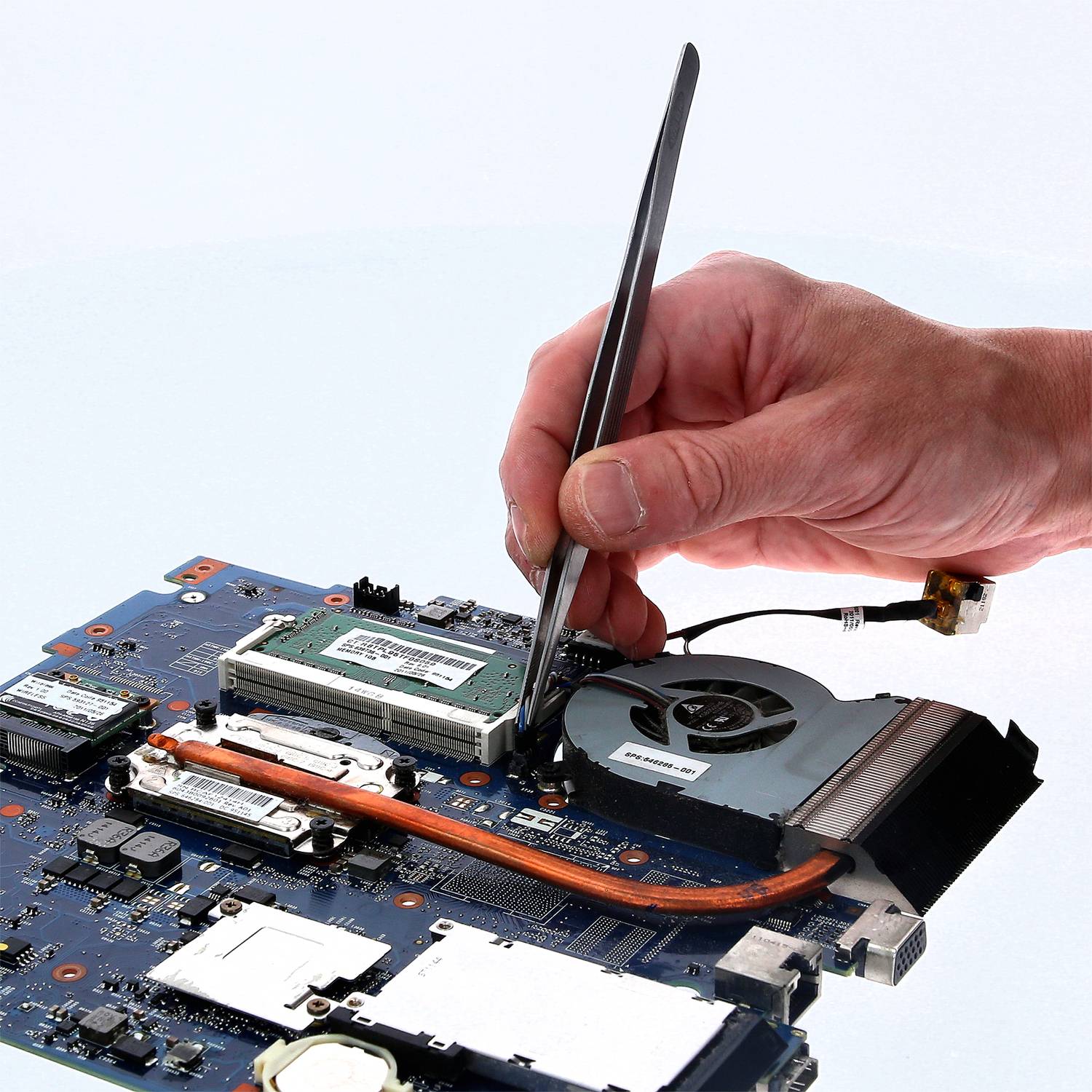 Eine Hand hält ein Schraubendreher und arbeitet an einer Computer-Motherboard, umgeben von verschiedenen elektronischen Komponenten.