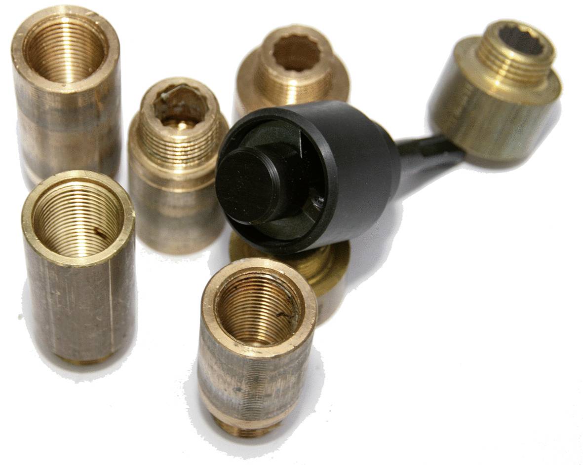 Messinghülsen und ein schwarzes Werkzeugaufsatz liegen auf weißem Hintergrund. Sieben Hülsen sind um das Werkzeug verteilt.