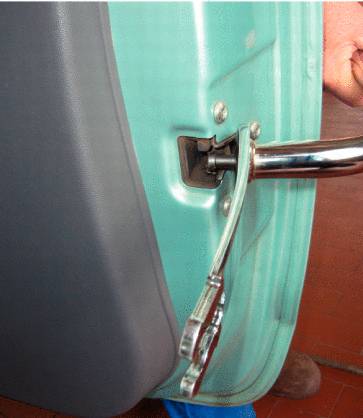 Eine Person zieht mit einem Werkzeug einen herausstehenden Stift aus der Verankerung der Autotür.