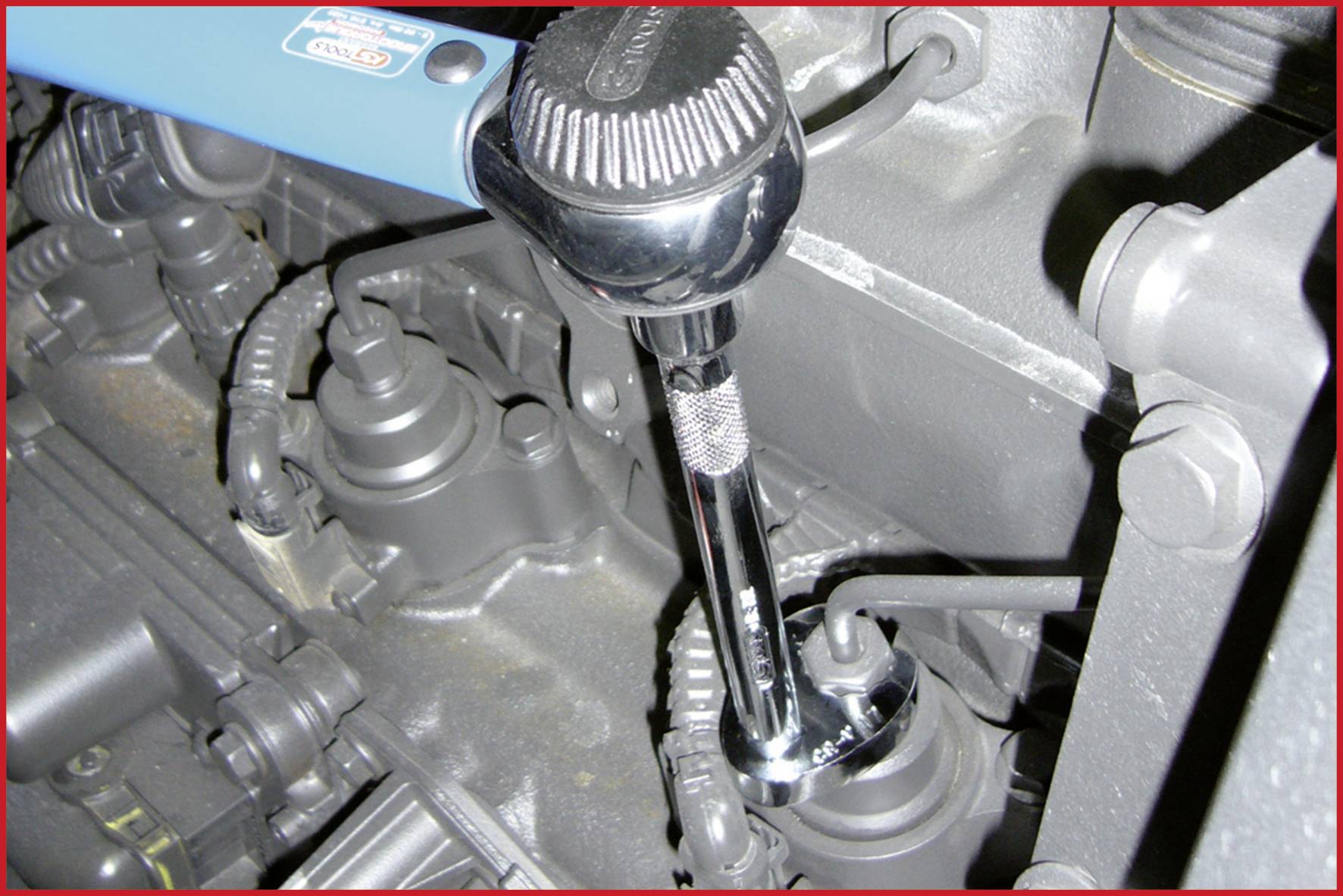 Ein Schraubenschlüssel wird verwendet, um eine Zündkerze in einem Motor zu befestigen.
