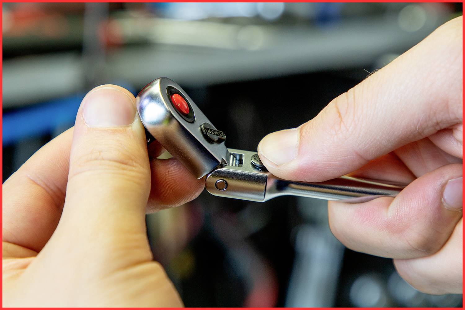 Nahaufnahme von zwei Händen, die einen Ratschenmechanismus an einem Werkzeug bedienen, fokussiert auf den Einstellknopf und die Zahnräder.