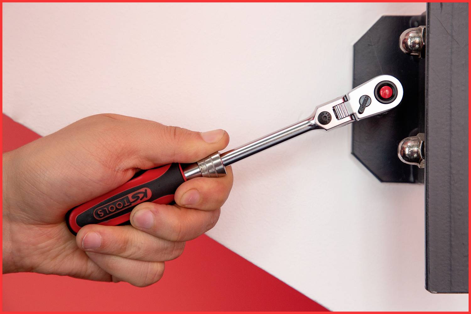 Eine Person verwendet einen Ratschen-Schraubenschlüssel, um eine Schraube an einer Metallhalterung an der Wand zu befestigen.