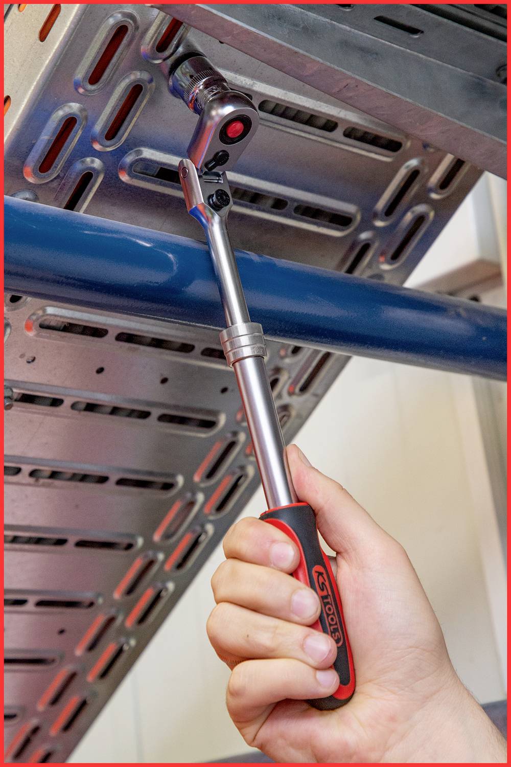 Eine Hand nutzt einen Drehmomentschlüssel, um eine Schraube an einem Metallgestell festzuziehen.