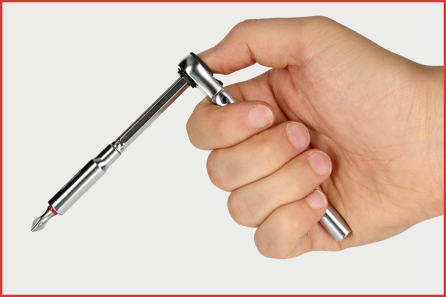 Hand hält einen Schraubenzieher mit Ratschenfunktion. Die Ratsche ist in einer Position, die eine flexible Drehbewegung ermöglicht.