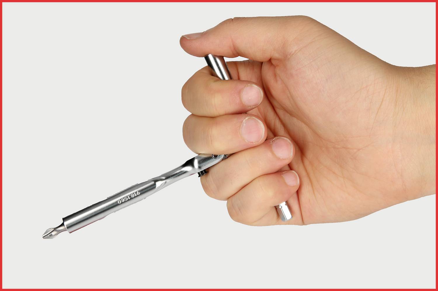 Eine Hand hält einen silbernen Kugelschreiber mit leicht geballter Faust. Der Stift ist in Schreibposition.