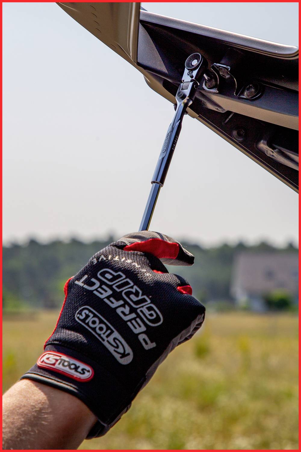 Eine Person zieht mit einem Drehmomentschlüssel eine Schraube an einem Motorrad an. Die Person trägt Handschuhe.