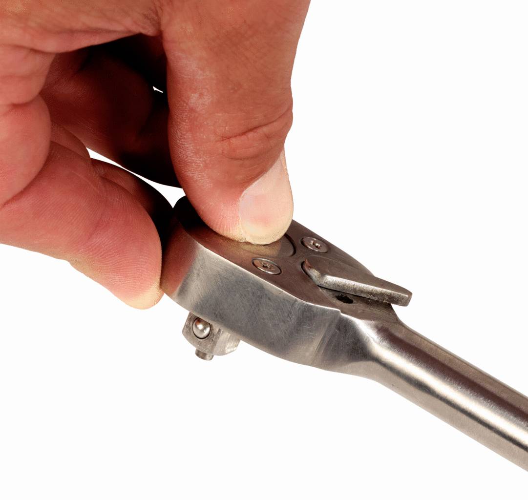 Eine Hand hält einen Ratschen-Schraubenschlüssel und justiert den Richtungshebel.