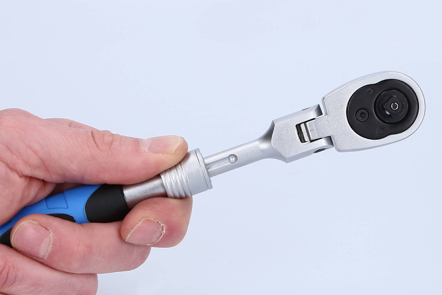 Eine Hand hält einen Drehmomentschlüssel, mit blauem Griff und silbernem Kopf, gegen einen weißen Hintergrund.