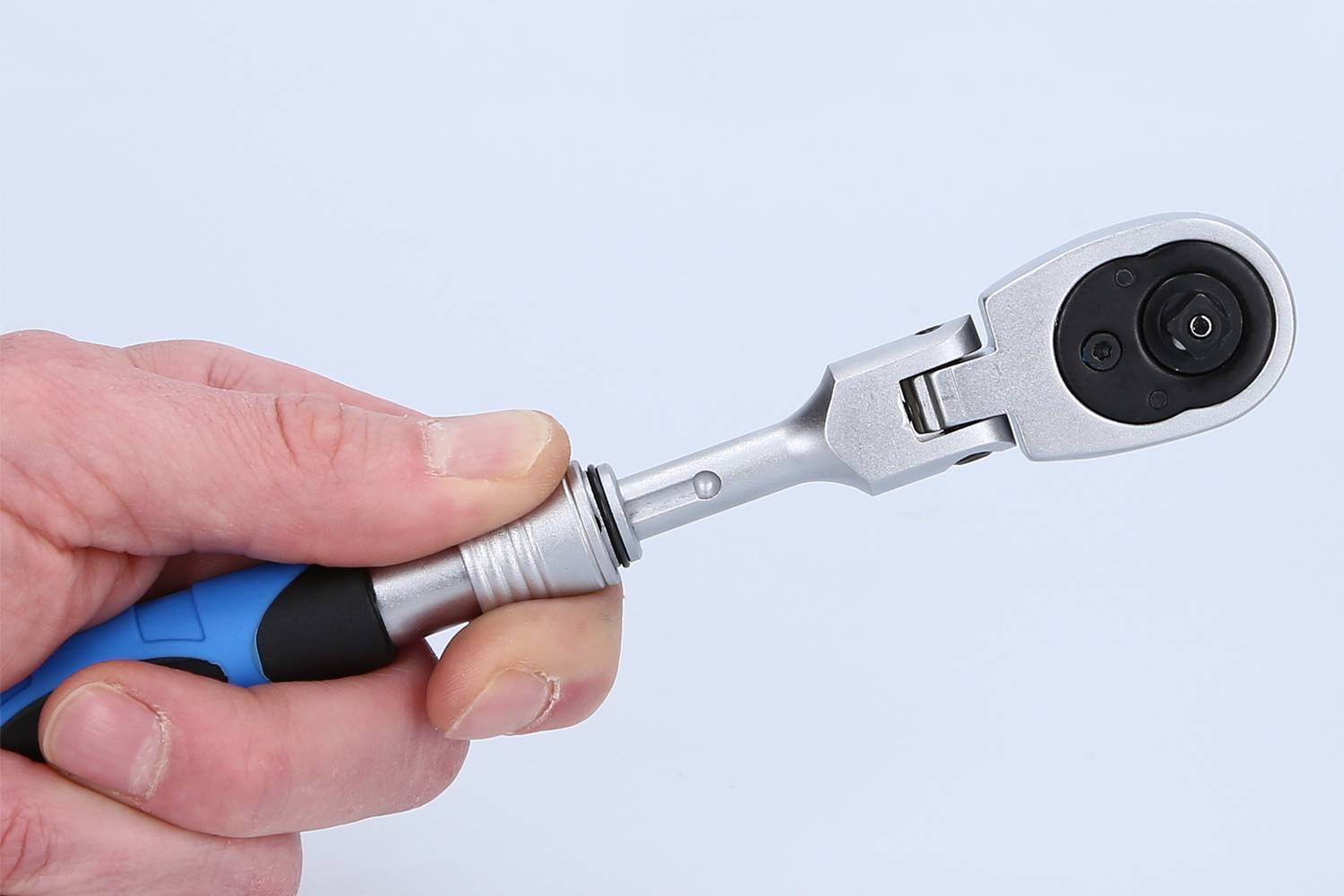 Eine Hand hält einen Drehmomentschlüssel mit einem blauen Griff. Der Kopf des Werkzeugs ist am Bildrand sichtbar.