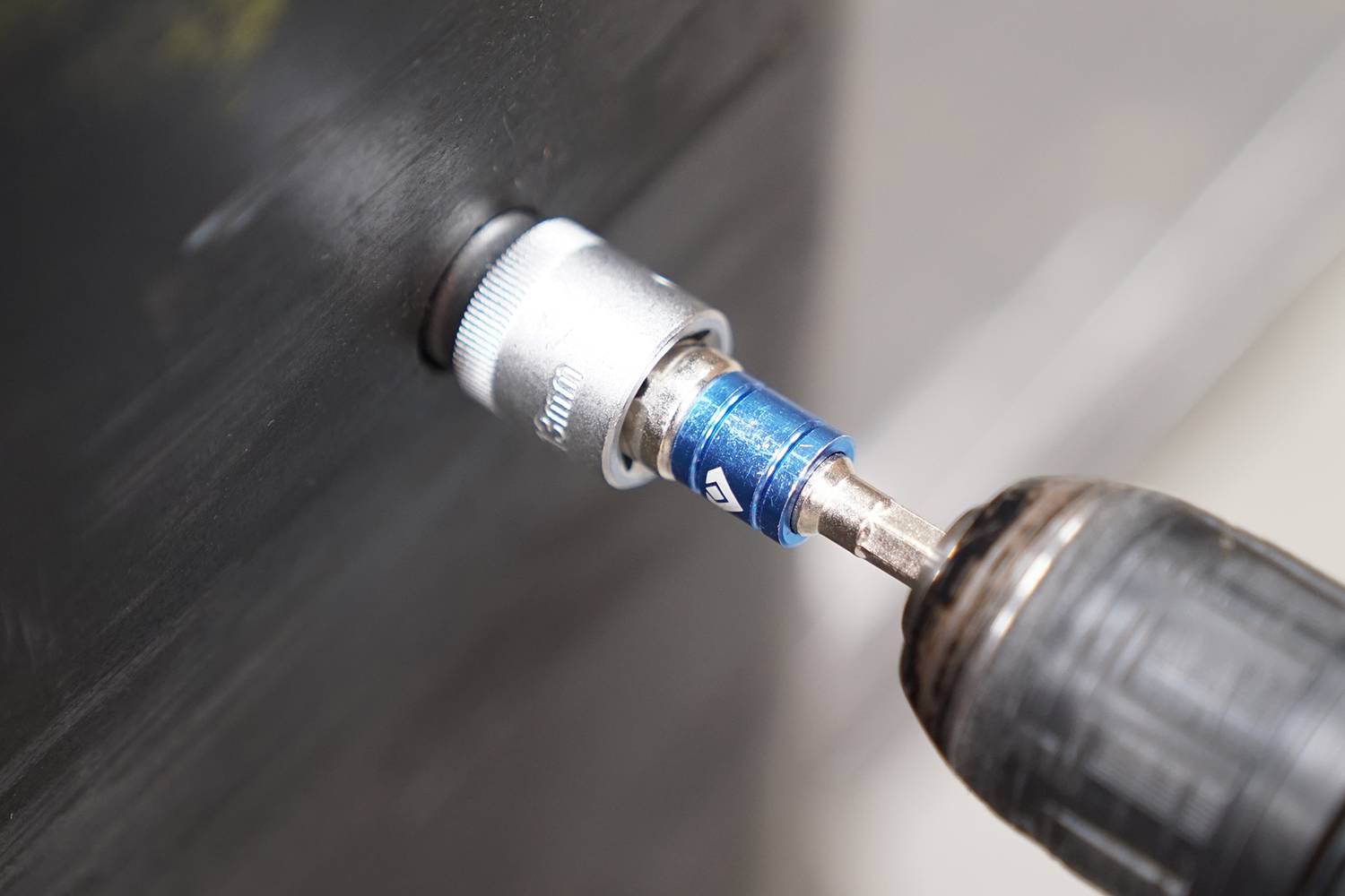 Ein Bohrschrauber wird verwendet, um eine Schraube in eine Metallplatte zu drehen, zeigt den Vorgang des Verschraubens.