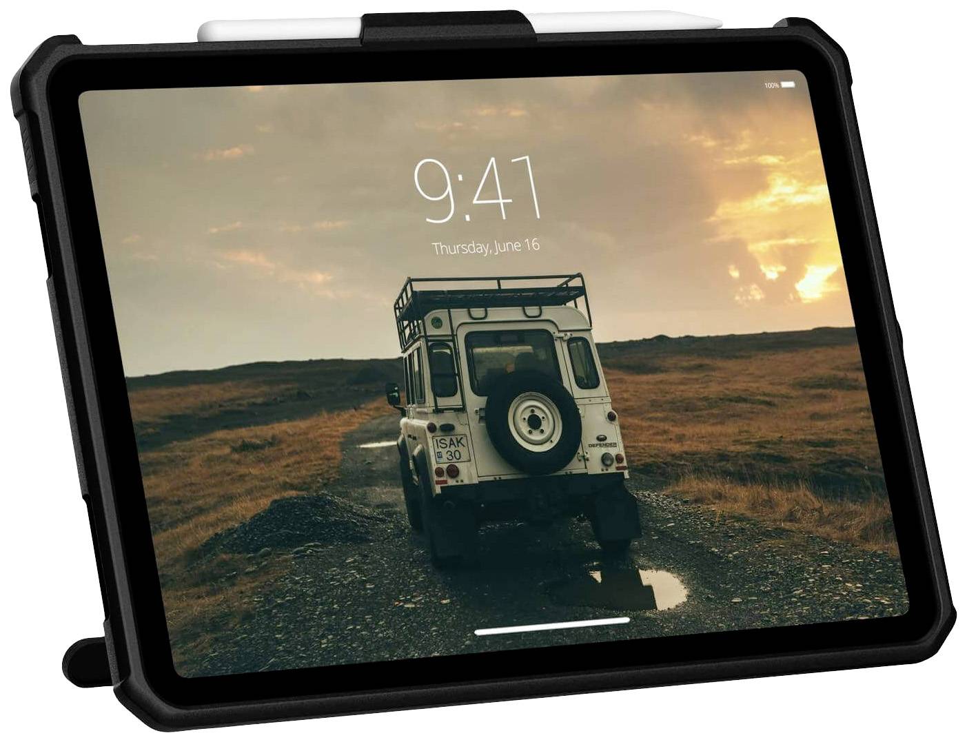 Ein Tablet mit einer Schutzhülle zeigt ein Bild eines Geländewagens auf einer Schotterstraße bei Sonnenuntergang.