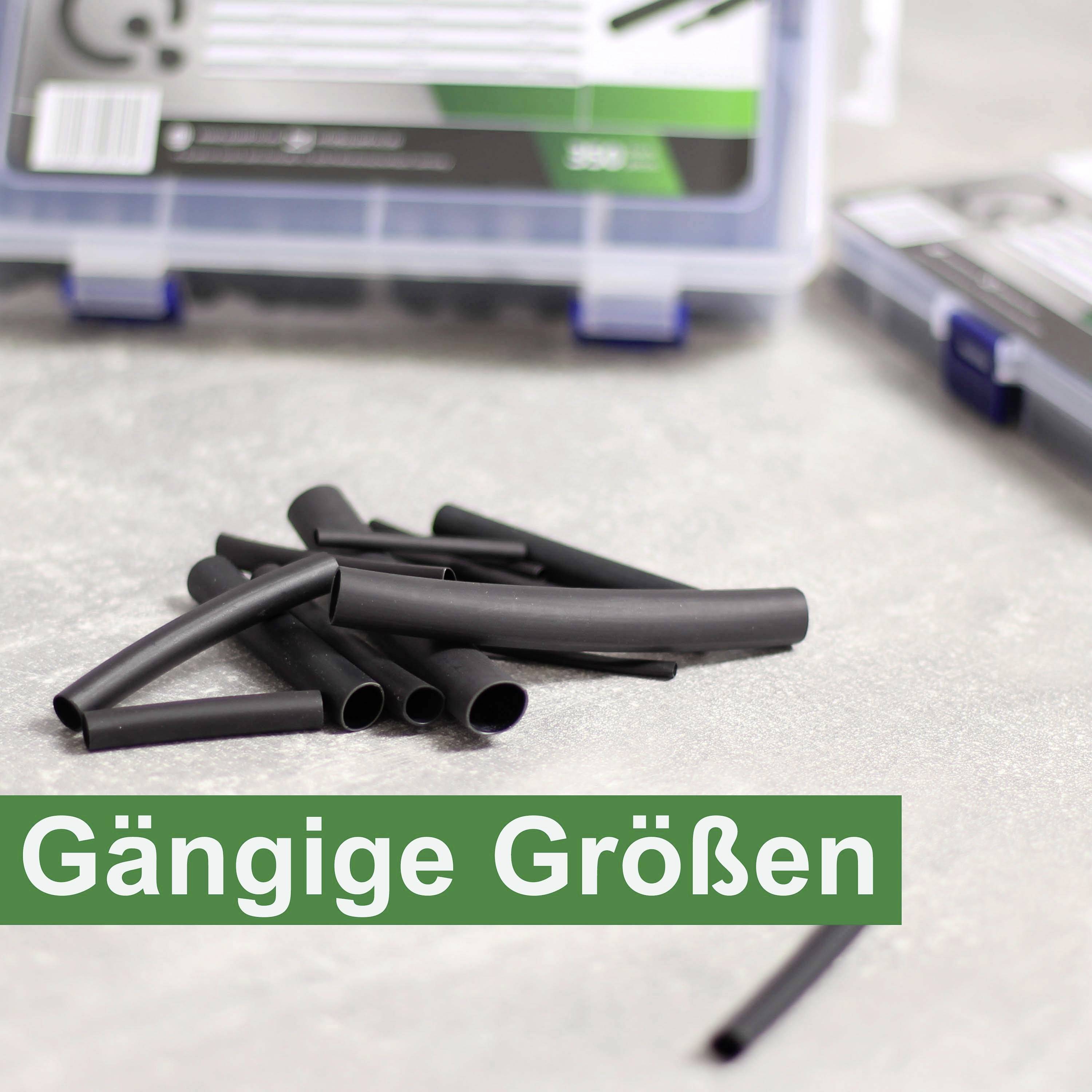 Schwarze Schrumpfschläuche in verschiedenen Größen liegen auf einem Tisch. Im Hintergrund eine geöffnete Box mit ähnlichen Schläuchen.