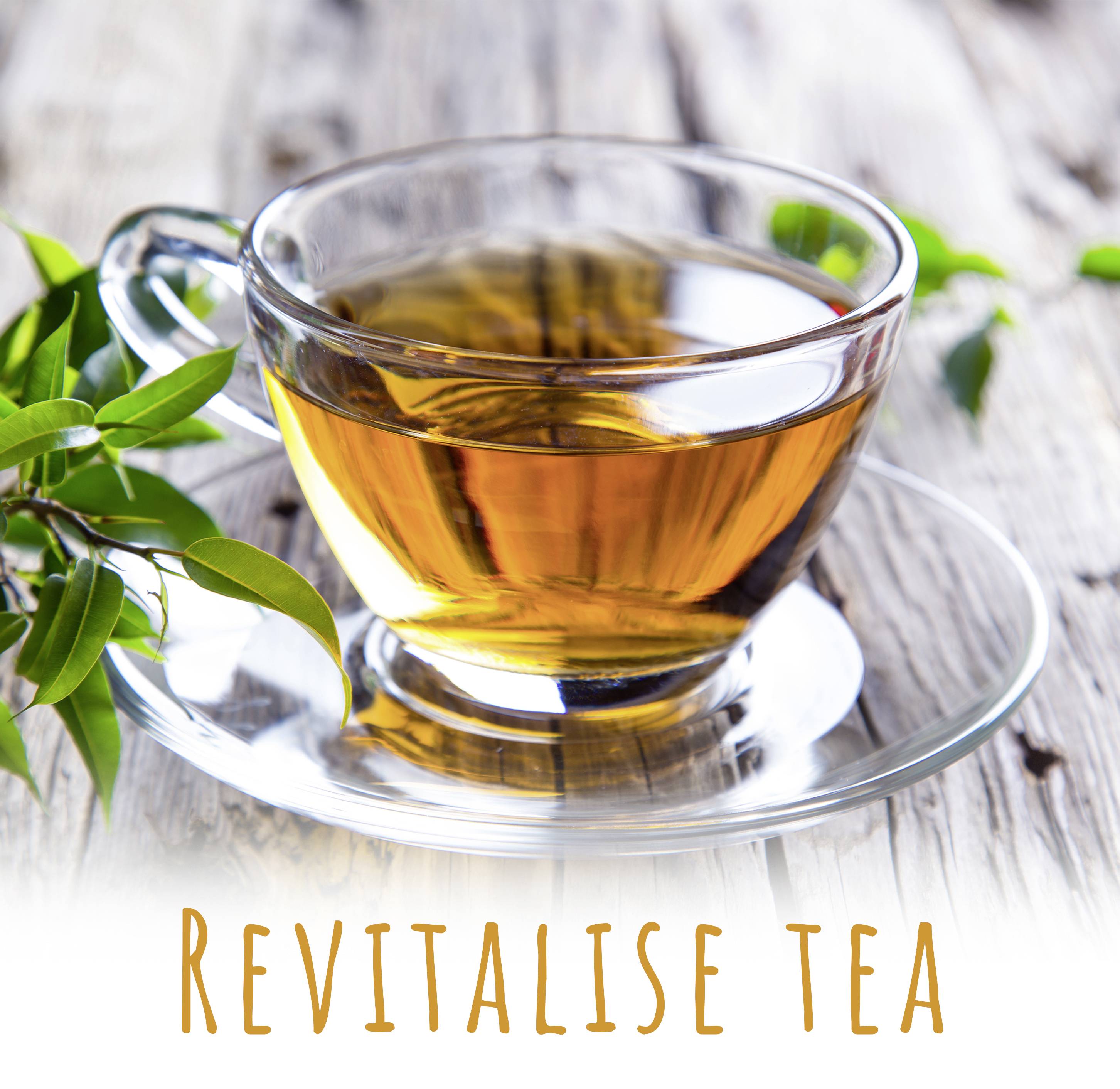 Eine Glastasse mit hellem Tee steht auf einem Holztisch, neben frischen Teeblättern. Text darunter: 'Revitalise tea'.