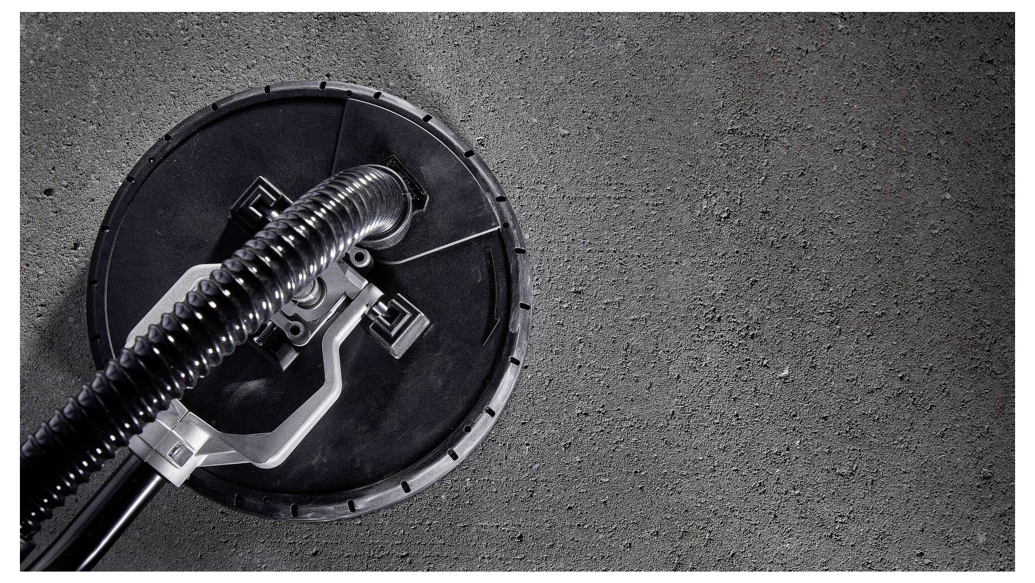 Industrieller Bodenschrubber kreisförmig, säubert Betonoberfläche. Links im Bild, rechts rauer Beton.