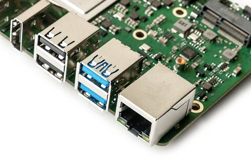 Nahaufnahme einer Leiterplatte mit mehreren USB-Anschlüssen und einem Ethernet-Port. Zeigt elektronische Komponenten und Anschlüsse.