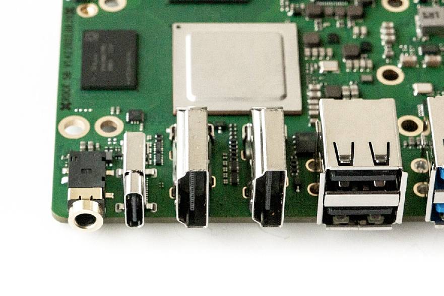 Nahaufnahme einer grünen Leiterplatte mit mehreren Anschlüssen, darunter USB-Ports und eine Audiobuchse.