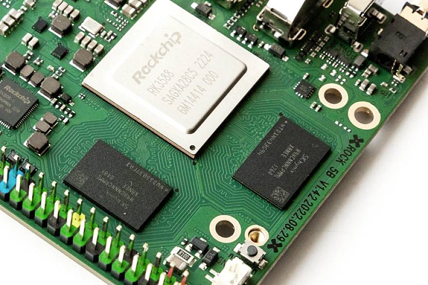 Nahaufnahme einer Computerplatine mit einem zentralen Prozessor (mit der Aufschrift 'Rockchip'), umgeben von verschiedenen Elektronikkomponenten und Schaltkreisen.