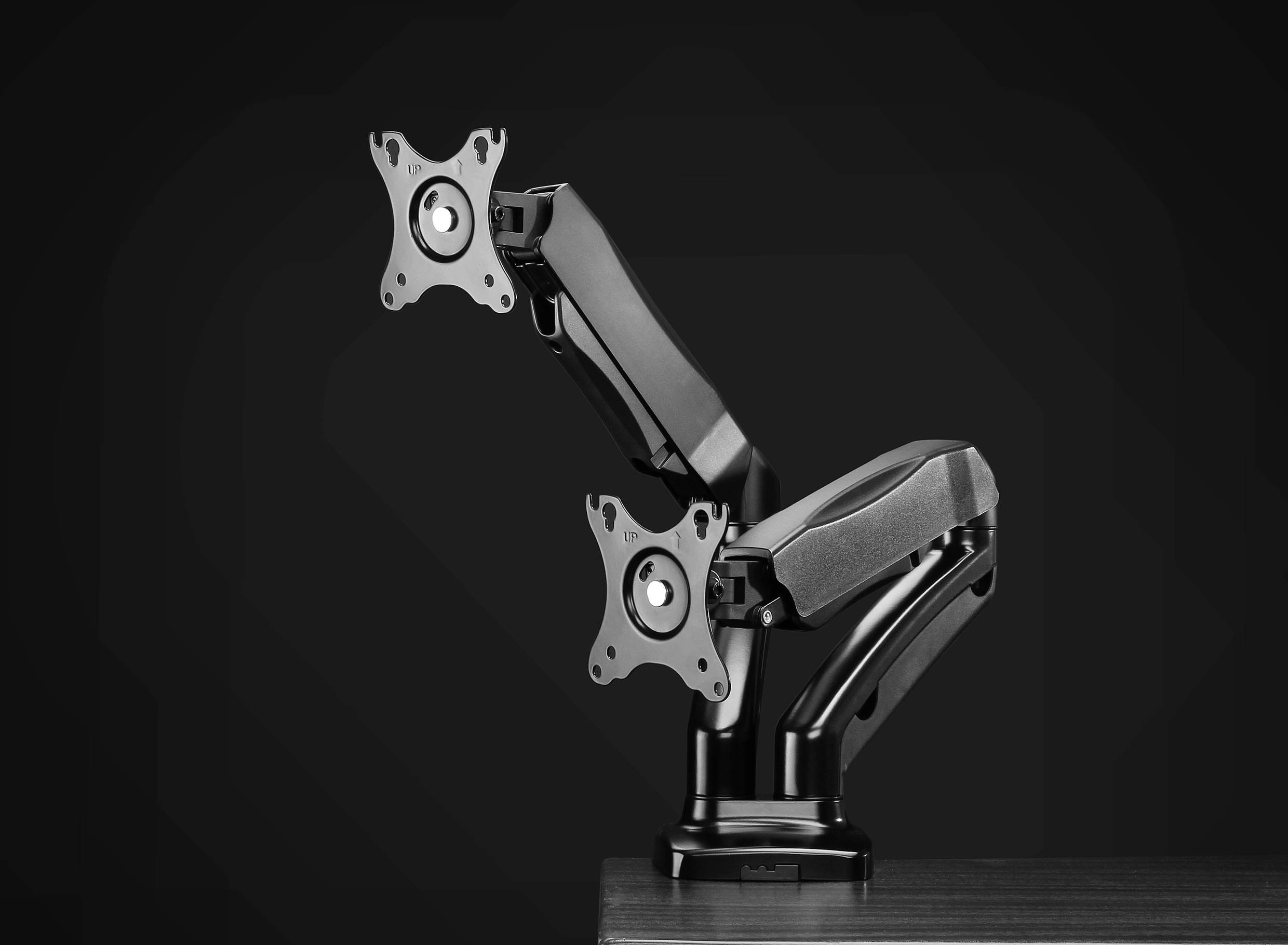 Schwarzer Dual-Monitor-Arm aus Metall auf Tisch montiert, bietet flexibles Schwenken und Neigen für zwei Monitore. Ideal für ergonomische Arbeitsplätze.
