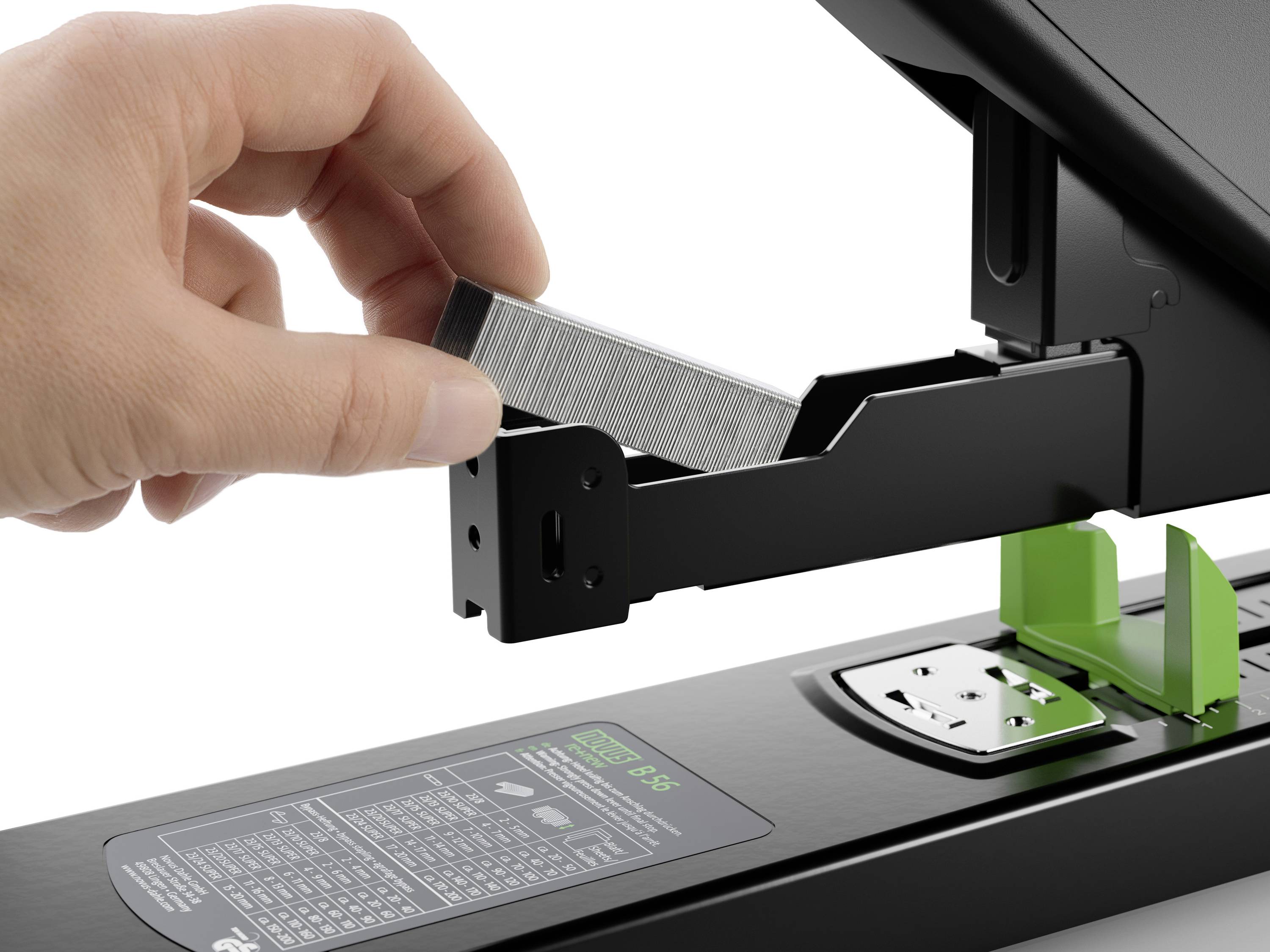 Eine Hand legt Heftklammern in ein geöffnetes schwarzes Heftgerät.