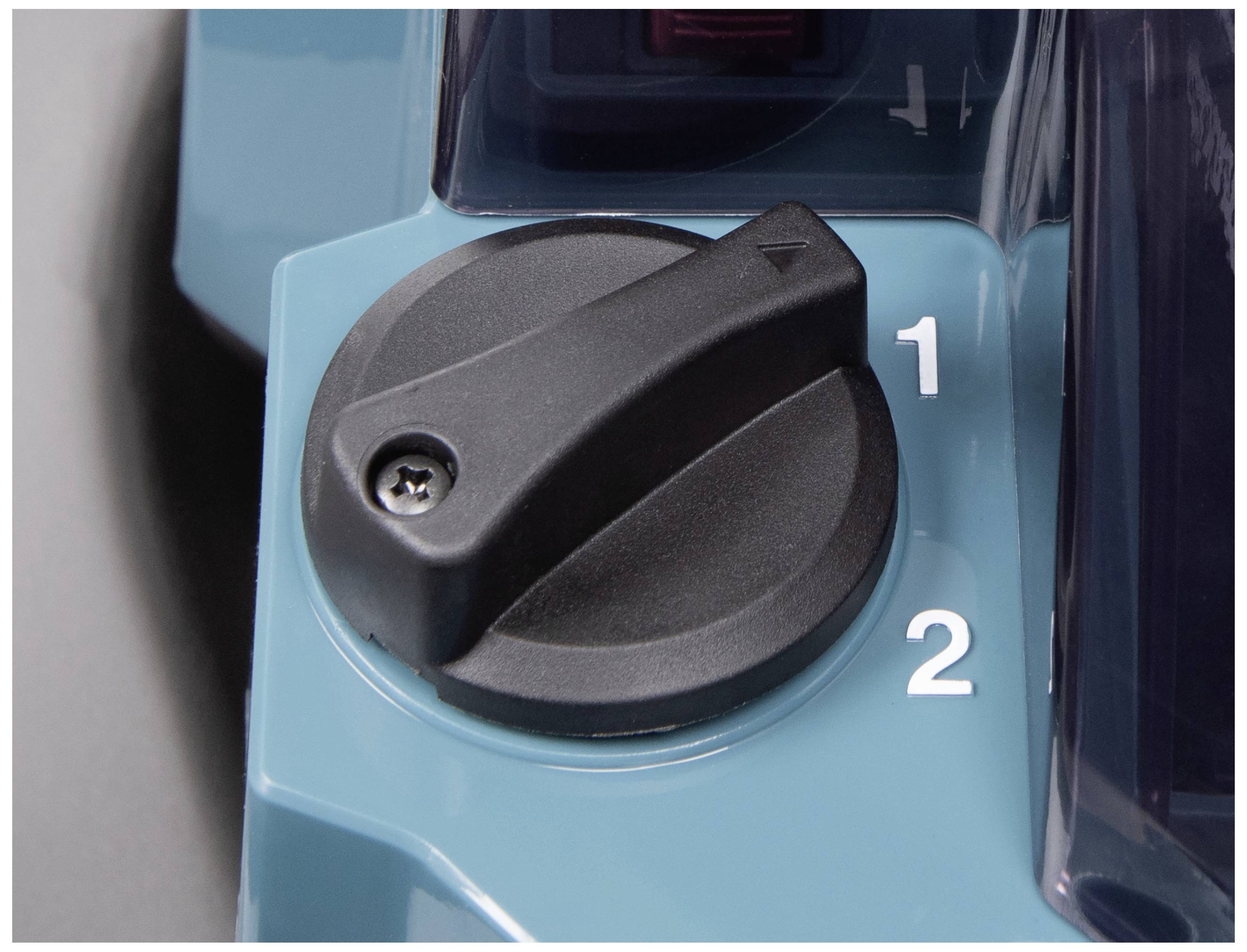 Ein schwarzer Drehschalter auf einer Maschine zeigt auf die Position '2'. Links daneben liegt die Position '1'.